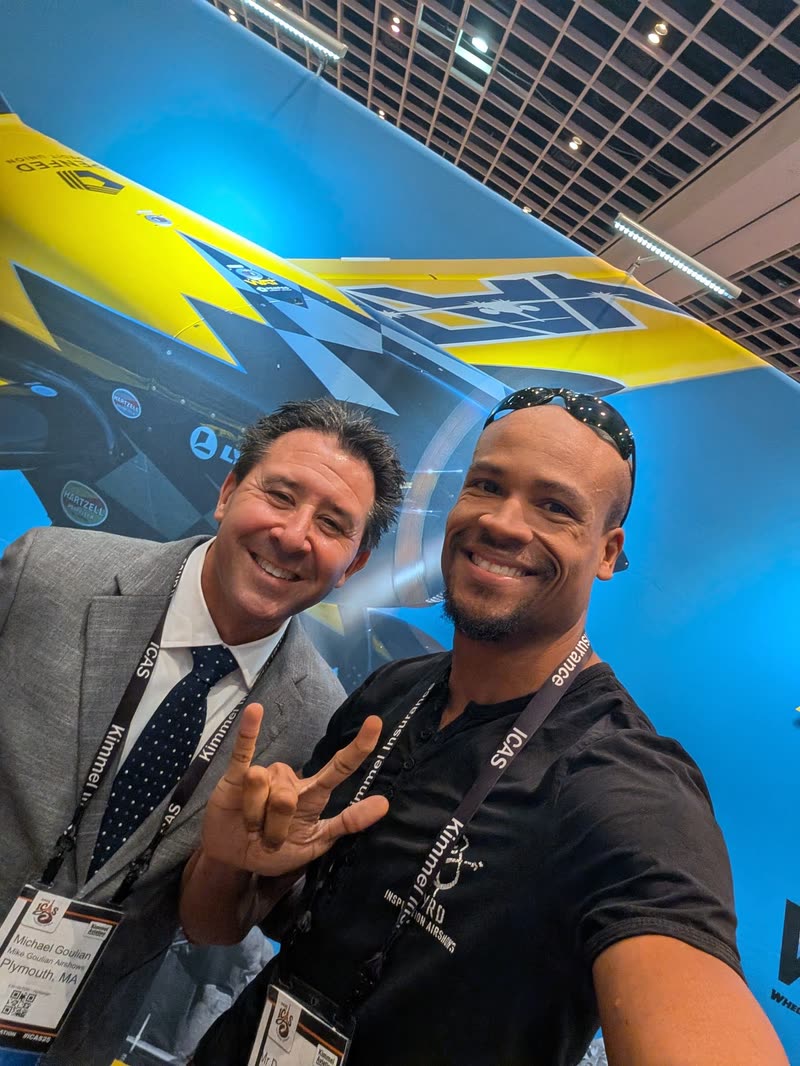 Doug Byrd, smiling, beside aerobatic champion Michael Goulian at the ICAS convention