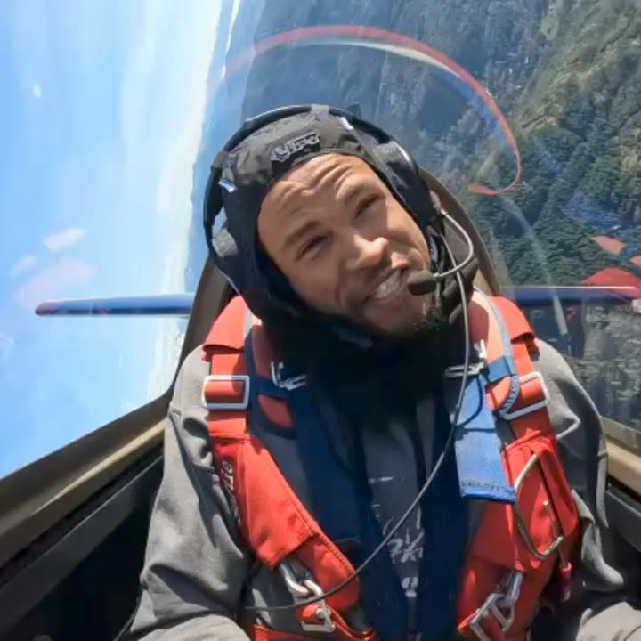 Doug Byrd in the cockpit of the Extra 300L, helmet and harness on, grinning.
