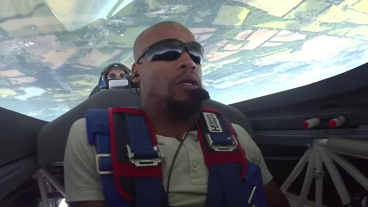 Doug Byrd in the cockpit of the Extra 300, inverted, farmland filling the canopy overhead.